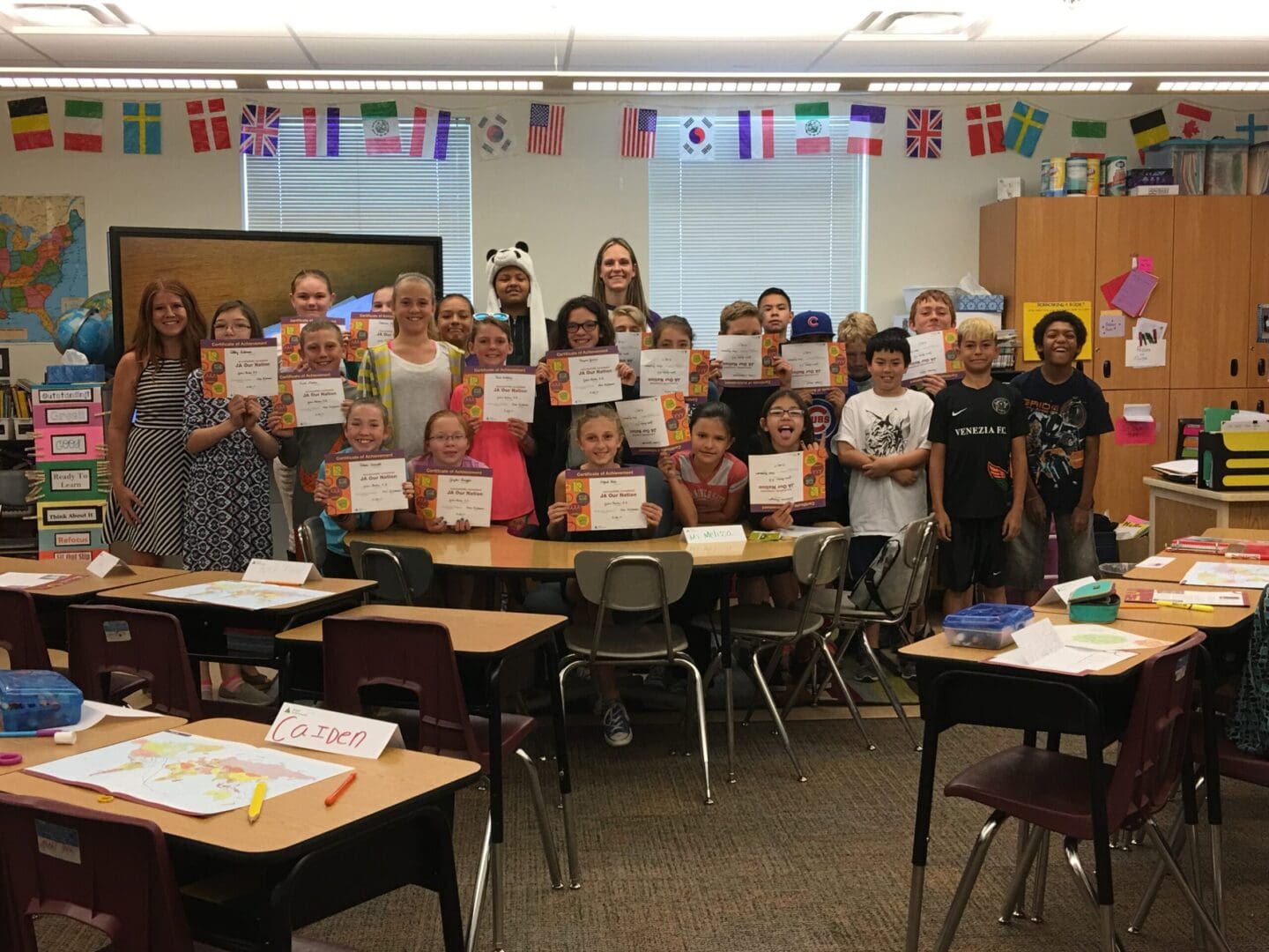 A group of students holding up their certificates.