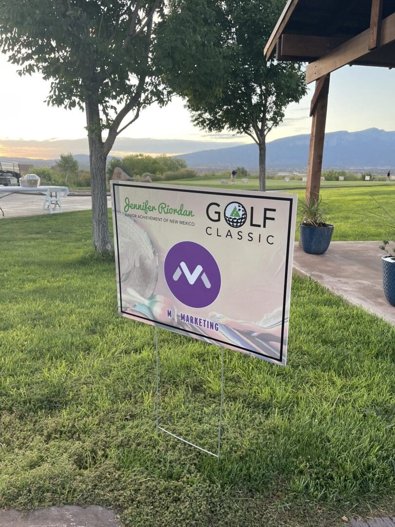 A sign is posted in the grass for golf classic.