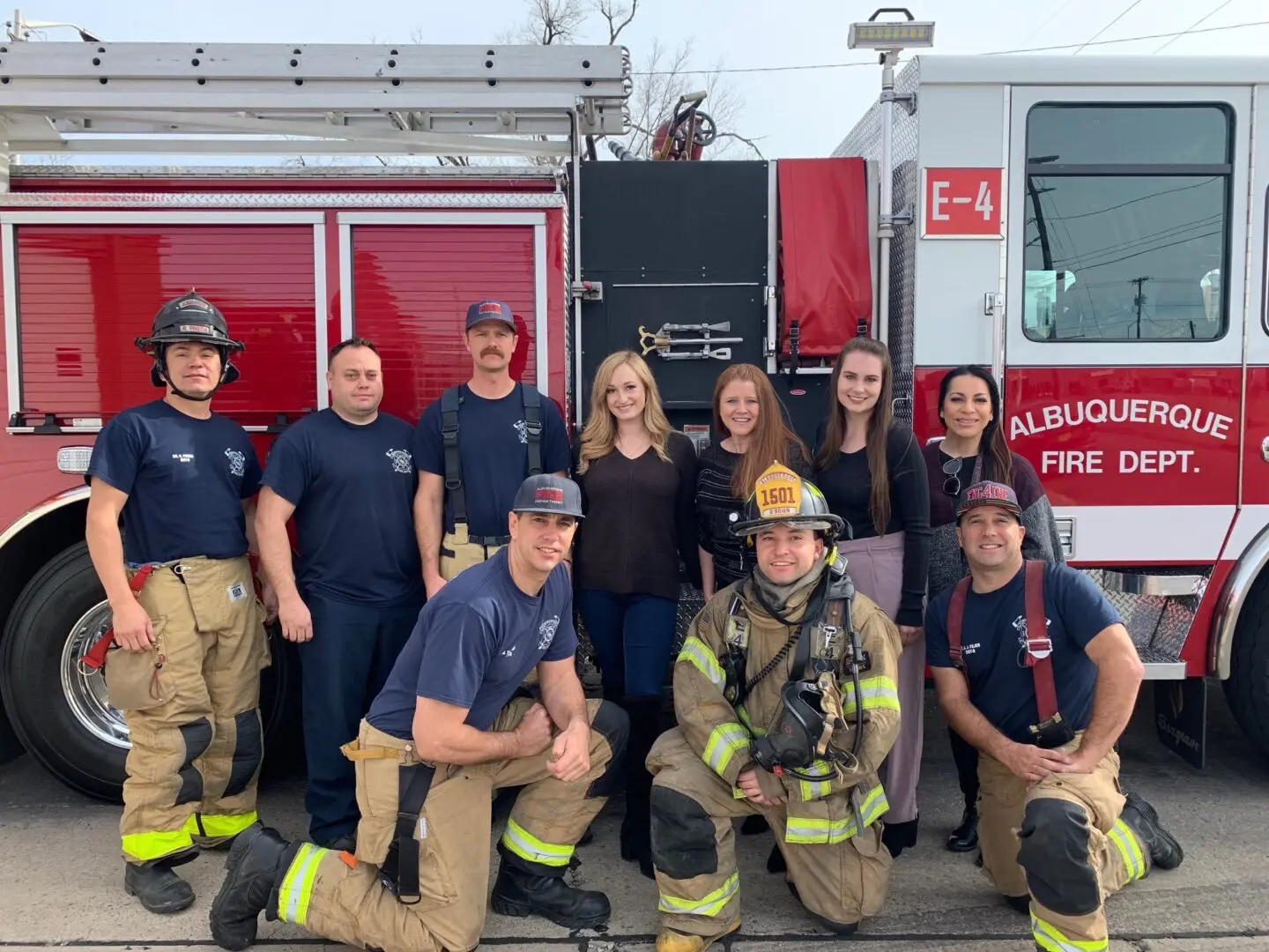 A group of people in front of a fire truck.