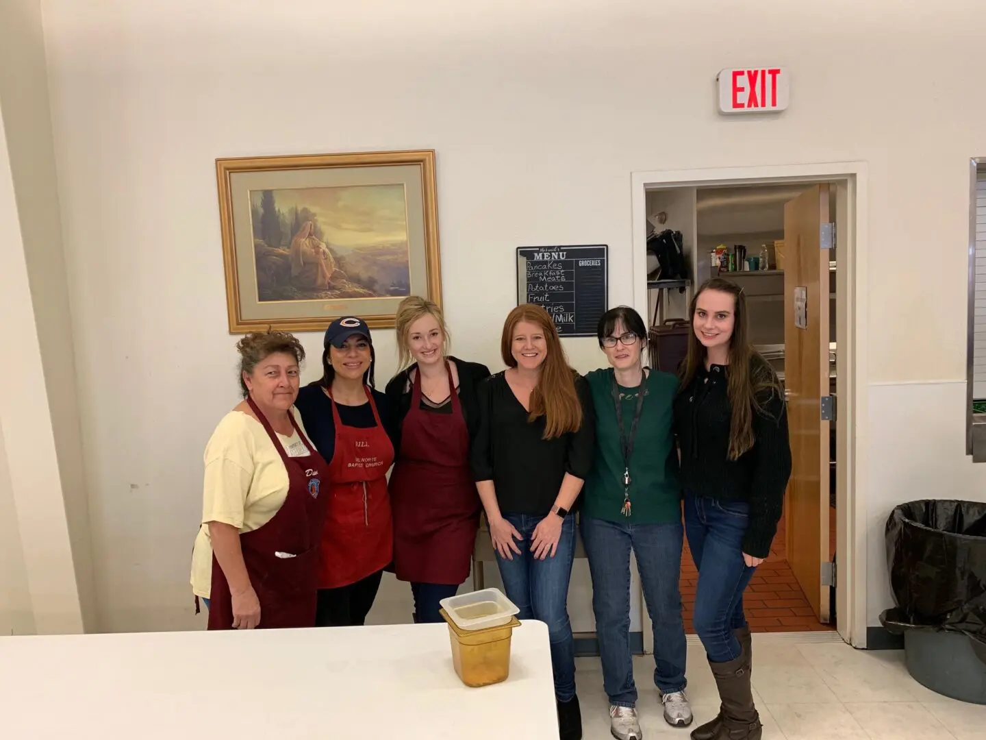 A group of women standing around a table.